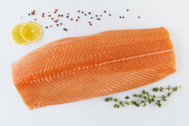 istock Fresh raw whole salmon fillet with seasoning on white backgrund 1299656421
