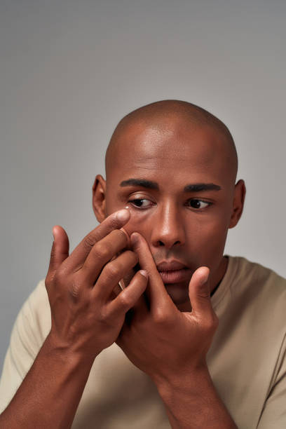 istock Careful young person putting in an eye lens 1299656427