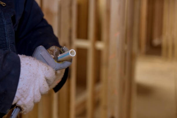 istock Plumbing building contractor cut a polypropylene pipe with scissors the hands of a worker in white gloves 1299658736