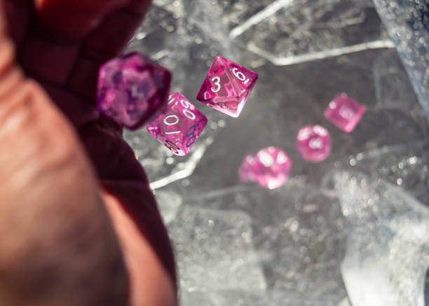 Hand throwing pink dice Set of pink role playing dice falling out of a hand on sheets of ice in the winter sun developing 8 stock pictures, royalty-free photos & images