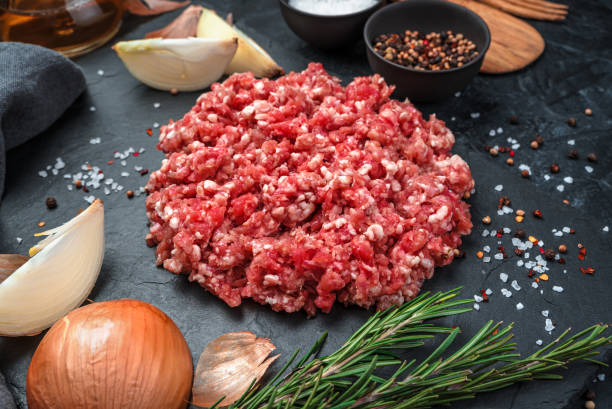 istock Minced turkey meat with onion and rosemary on a black background 1299661366