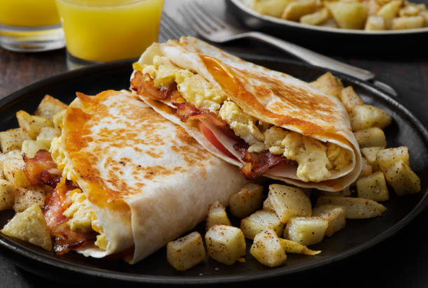 istock The Folded Breakfast Tortilla with Scrambled Eggs, Bacon, Tomato and Cheese 1299661435