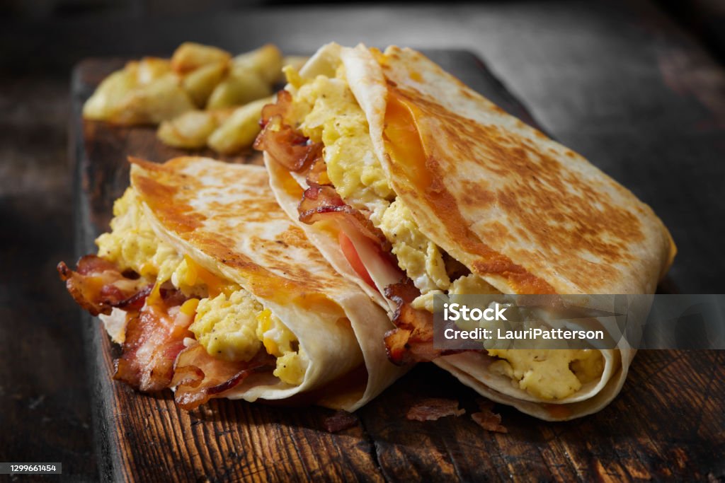 The Folded Breakfast Tortilla with Scrambled Eggs, Bacon, Tomato and Cheese The Folded Tortilla made famous on social media during the pandemic Breakfast Stock Photo