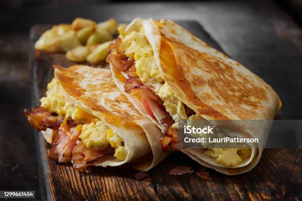 The Folded Breakfast Tortilla With Scrambled Eggs Bacon Tomato And Cheese Stock Photo - Download Image Now