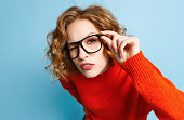 Curious woman in glasses looking at camera