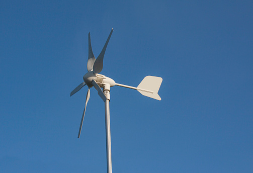 Close up of modern rotating anemometer on top of a pole with deep blue sky background. Copenhagen, Denmark - 13 January 26, 2021.