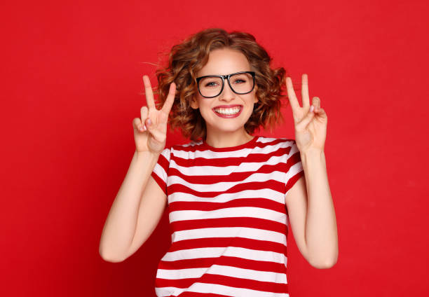 istock Happy young female gesturing V sign 1299662524