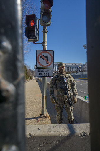 Washington D.C., January 30, 2021:  Fences were erected around Capitol after January 6 when pro-Trump protesters rallied in DC ahead of Electoral College vote count and some stormed into the Capitol. A National Guard soldier on guard at one entrance of the fenced area.