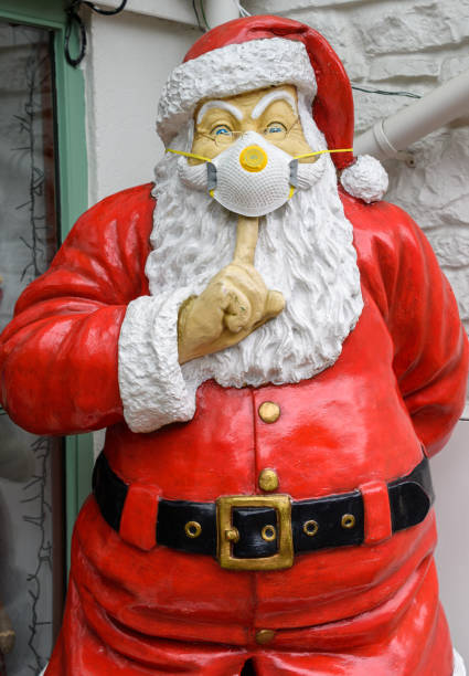 A statue of Santa Claus wearing a face mask in teh light of the Coronavirus Pandemic Cheddar Gorge, United Kingdom - August 23 2020:  A statue of Santa Claus wearing a face mask in teh light of the Coronavirus Pandemic cheddar gorge stock pictures, royalty-free photos & images