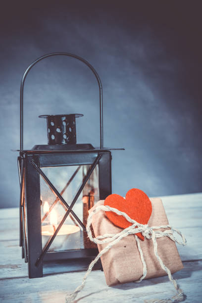 istock handmade gift with a red heart attached. an illuminated lantern in the background. eco friendly concept 1299663479