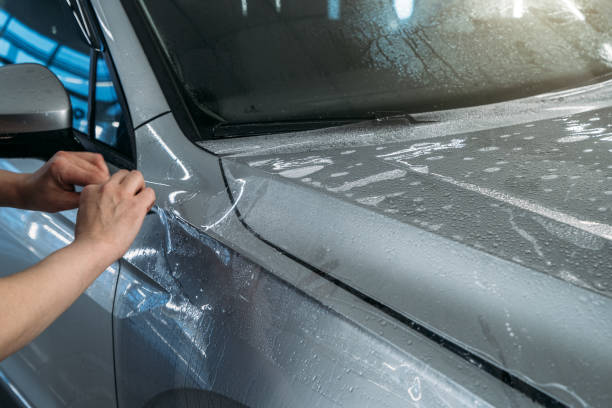 istock Installing PPF or Paint Protection Film on car as protective polymer skin from scratches and rock chips 1299663667