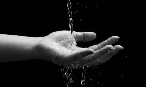 istock Woman hand with water splash 1299665471
