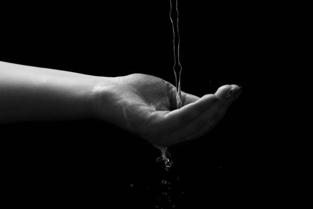 istock Woman hand with water splash 1299665476