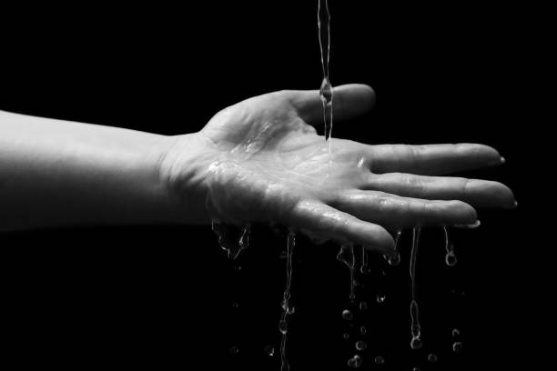 istock Woman hand with water splash 1299665489
