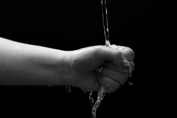 istock Woman hand with water splash 1299665492