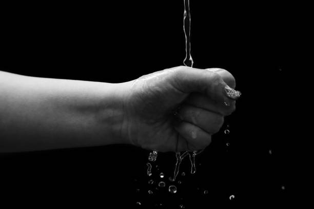 istock Woman hand with water splash 1299665504