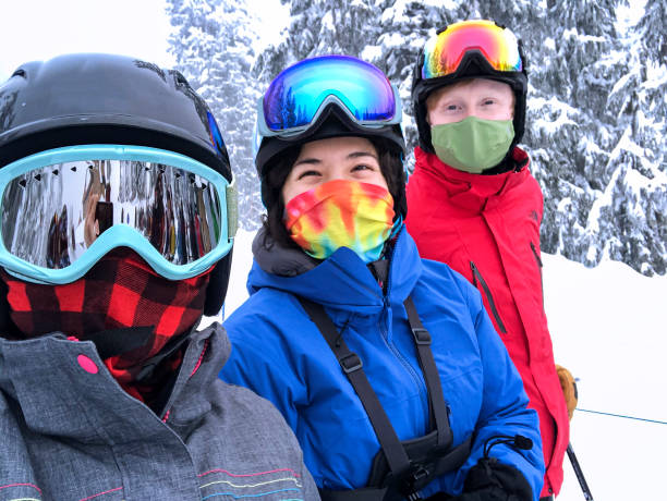 multi-ethnic family group skiing wearing neck gaiters and face mask - mt seymour provincial park fotografías e imágenes de stock