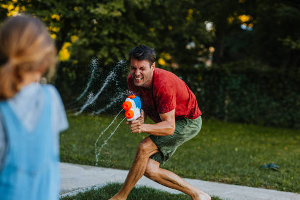 istock Father and son having water gun fight in the backyard 1299666645
