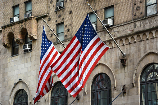 Front view of waving American national flags on building in New York City, Manhattan, New York, USA