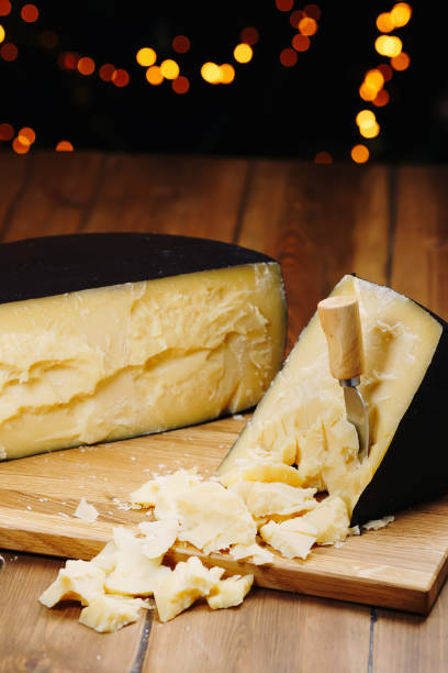 istock Medium hard cheese head parmesan on wooden board, with cheese parmesan knifes 1299667533