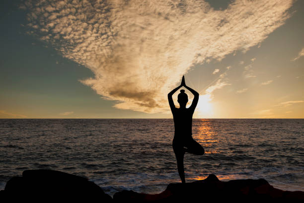 istock Silhouette young woman practicing yoga 1299669798