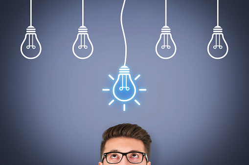 Creative idea concepts with light bulbs on touch screen. To remind the importance of innovation in the business world. Businessman holds in his hand a light bulb. New idea in human palm. To be ordinary or different. Innovation brings success.