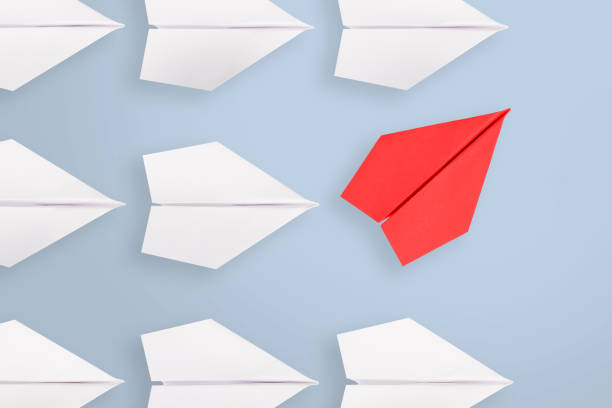 istock Leadership concepts with red paper airplane leading among white 1299670446