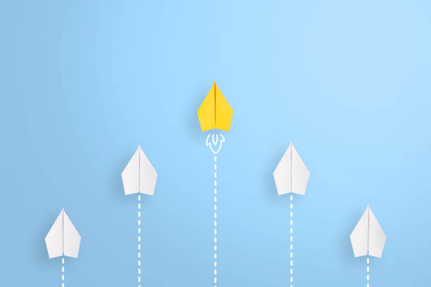 istock Leadership concepts with yellow paper airplane leading among white 1299670913
