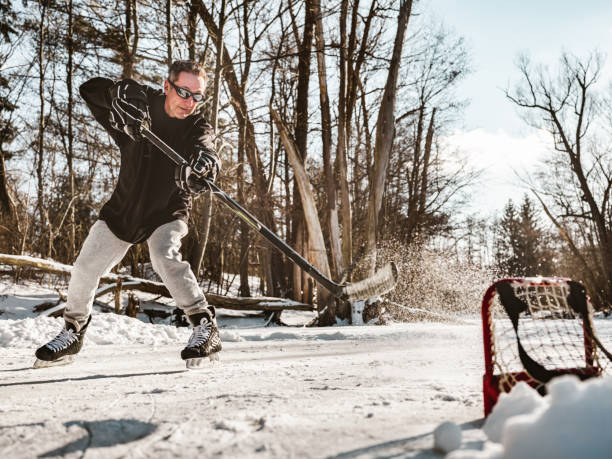 istock Mature man playing hockey outdoors 1299671902