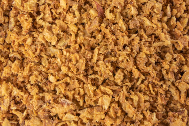 istock Crispy carmelized fried onion flakes background. Spices and food ingredients. 1299672686