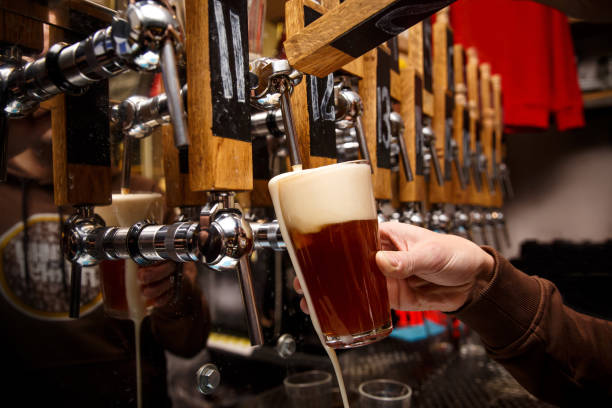 istock Bartender pouring from tap fresh beer into the glass in pub 1299672873