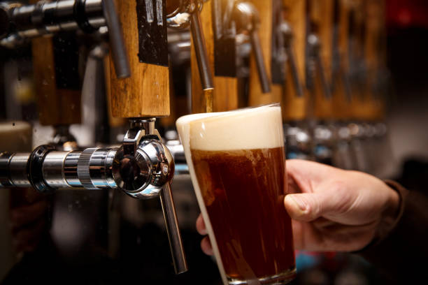 istock Bartender pouring from tap fresh beer into the glass in pub 1299672877