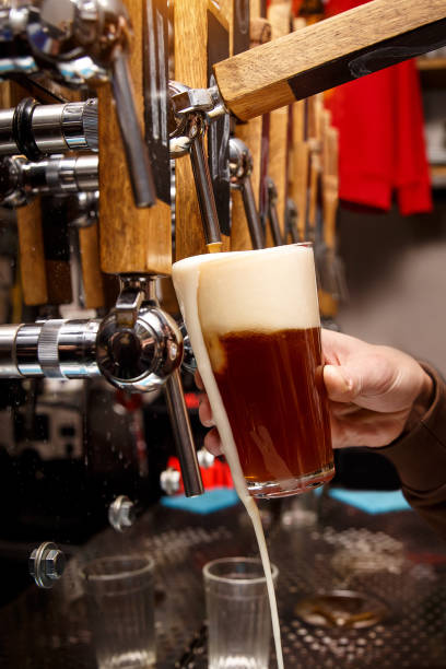 istock Bartender pouring from tap fresh beer into the glass in pub 1299673401