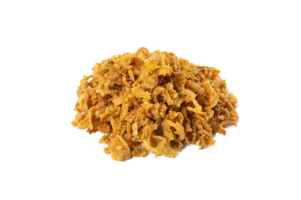 istock Crispy carmelized fried onion flakes heap isolated on white background. Spices and food ingredients. 1299673617