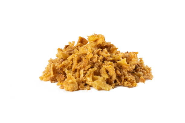 istock Crispy carmelized fried onion flakes heap isolated on white background. Spices and food ingredients. 1299673843