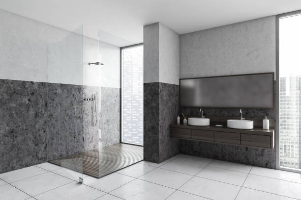istock Grey and white bathroom with shower, two sinks and big window 1299674729