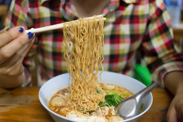 istock Women eat instant noodles 1299676437