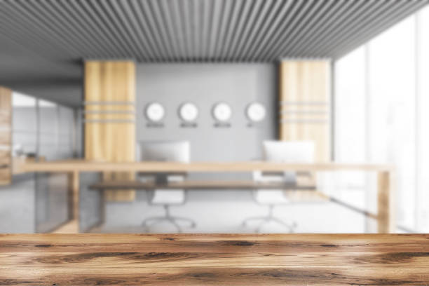 istock Table in blurry gray and wooden office interior with reception 1299676526