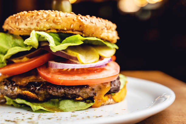 istock Burger with beef tomato onion and lettuce leaves on a plate served at restaurant 1299678195
