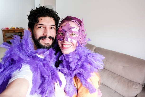 Couple taking selfie celebrating carnival at home stock photo