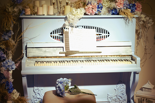 Vintage blue piano decorated with flowers and candles