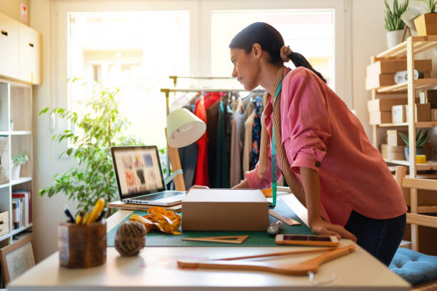 istock Young small business owner receiving orders and packing boxes for home delivery 1299679255