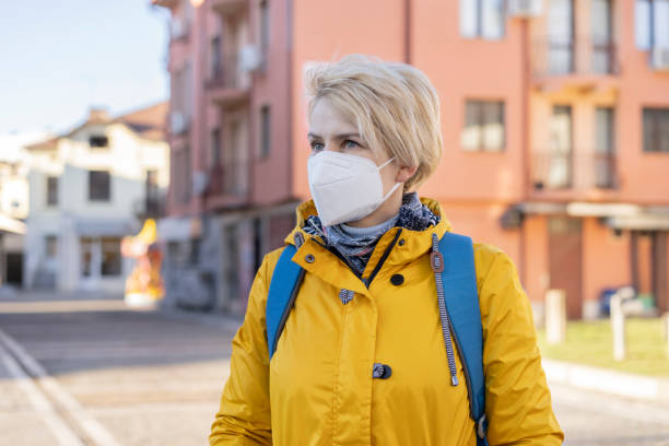 Woman wearing in EU obligatory FFP2/KN95/N95/ protective mask Portrait of a woman wearing protective face mask in accordance with the European health guidelines FFP2/KN95 kn95 face mask photos stock pictures, royalty-free photos & images