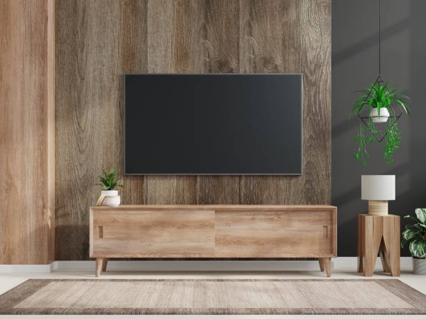istock Mockup a TV wall mounted in a dark room with a dark wood wall. 1299682681