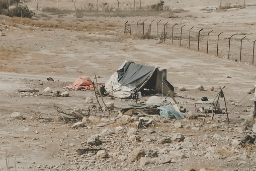 Bedouin houses in the desert near Dead Sea. Poor regions of the world. A indigent Bedouin sitting at the tent. Poverty in Jordan. middle East