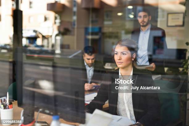 People Working In An Office Seen Through The Window In A Business Company Stock Photo - Download Image Now