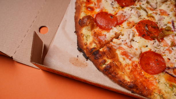 istock Close up of burnt pizza with different ingredients in box. Appetizing pizza with burnt edge 1299691903