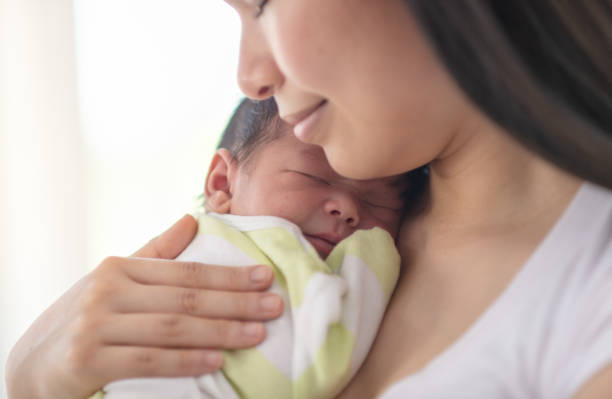 istock Mother snuggling newborn baby 1299693792