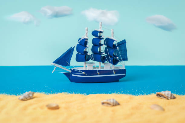 istock A blue sailboat sailing past a sandy beach. 1299694606