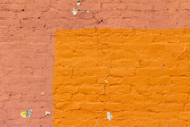 istock Old deteriorating two color rust red color painted brick wall texture background 1299694729